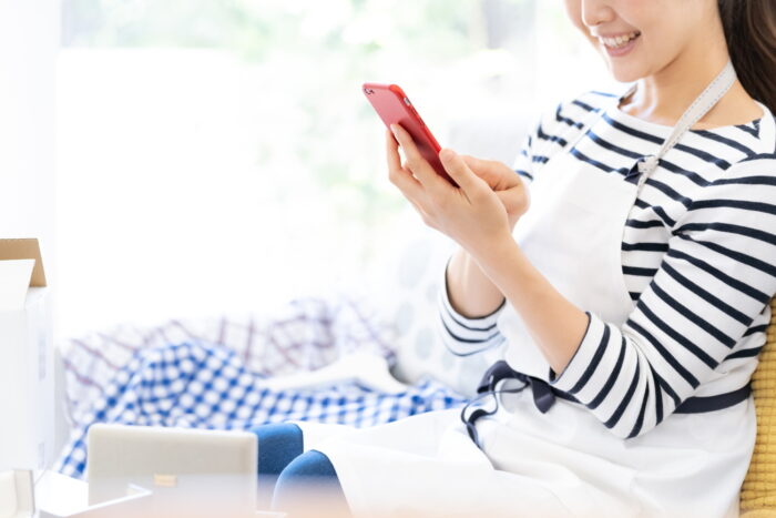 掃除代行業者をスマートフォンで調べる女性